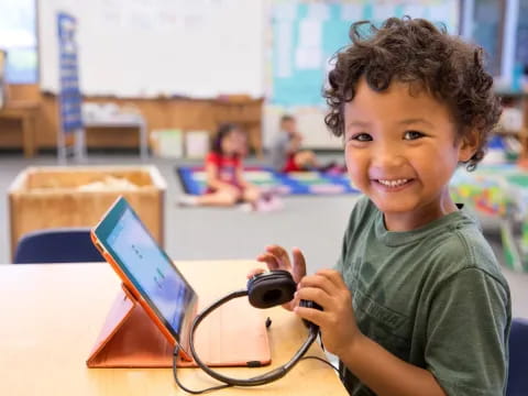 a young boy holding a device