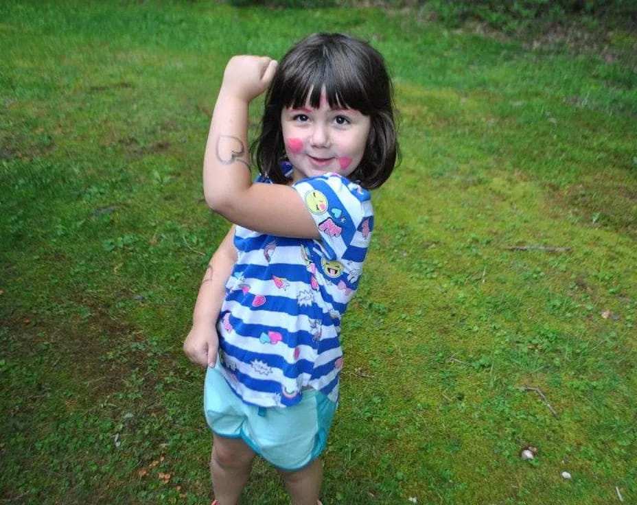 a girl standing in a grassy area