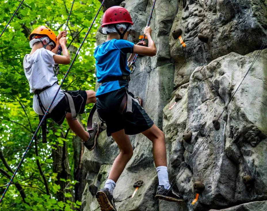 a couple of people climbing a rock