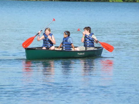 a group of kids in a canoe