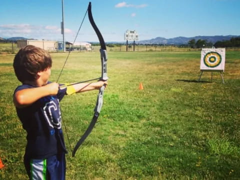 a boy shooting a bow and arrow