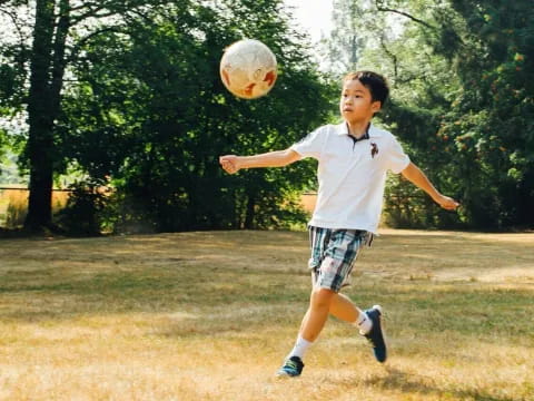 a boy jumping to catch a ball