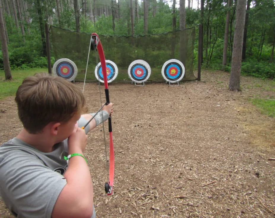 a boy shooting a bow and arrow