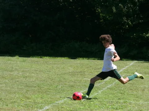 a boy kicking a football ball
