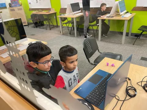 a few boys working on a laptop