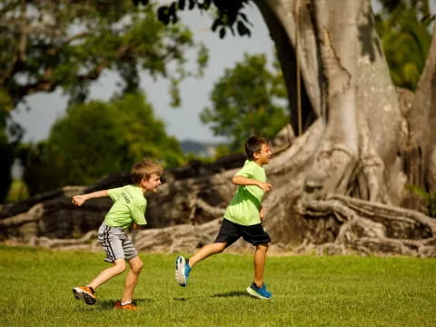 two boys running on grass