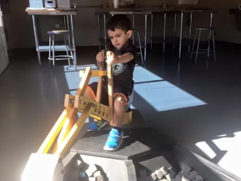 a boy sitting on a model airplane
