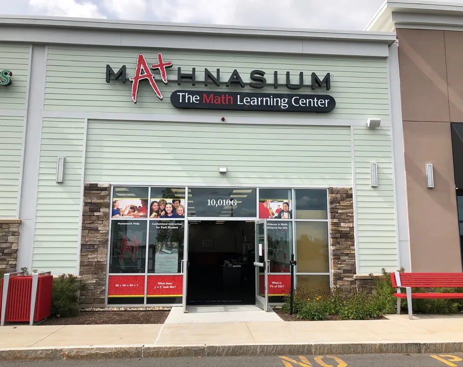 a store front with a red bench