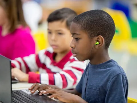 a few young boys using a laptop