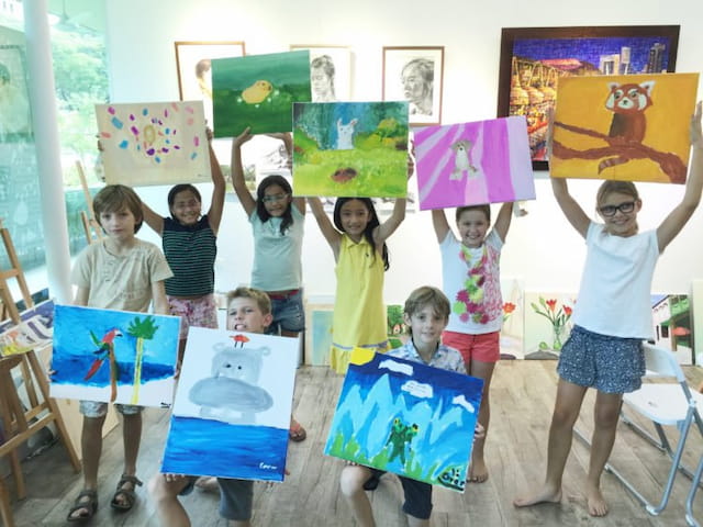 a group of children holding up colorful paper