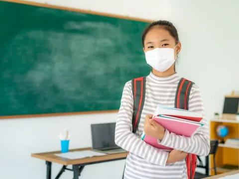a young girl in a white mask