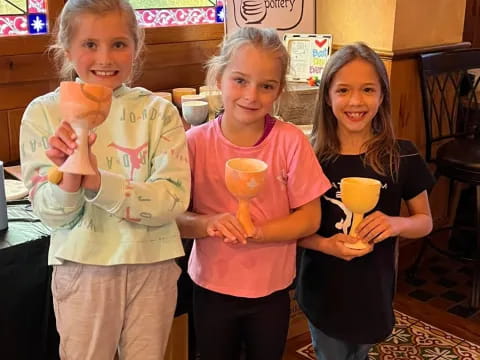 a group of girls holding cups