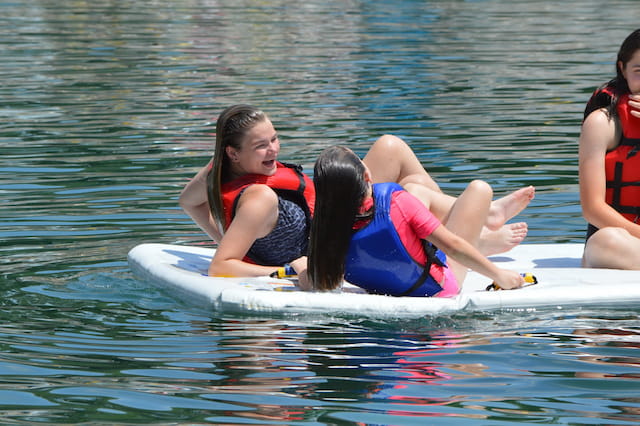a group of girls on a surfboard