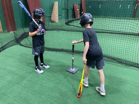 kids holding bats on a field