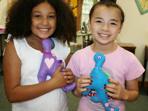 a couple of girls holding a toy