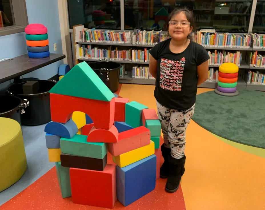 a child standing next to a toy