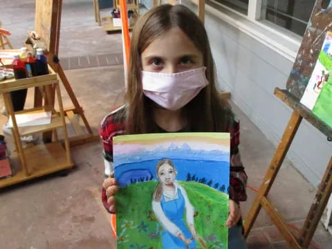 a girl holding a drawing
