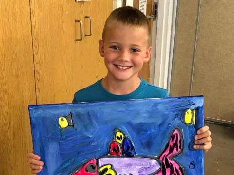 a boy holding a blue box