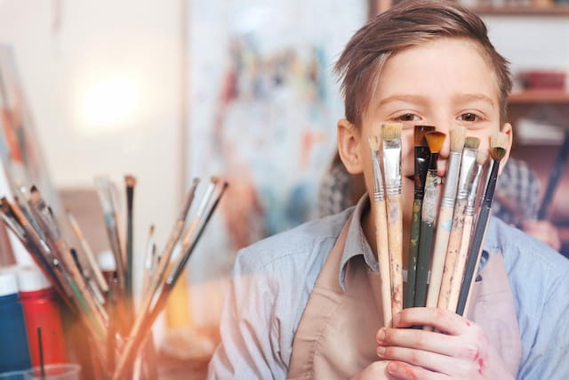 a young boy holding a pencil