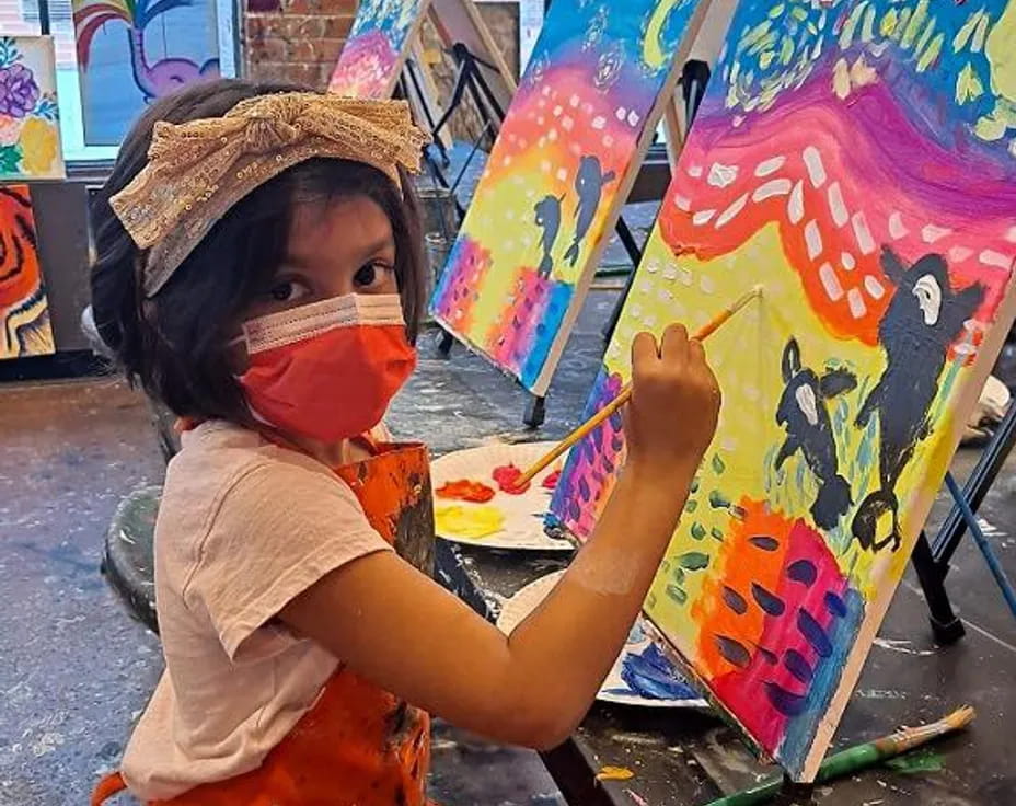 a young boy painting on a wall