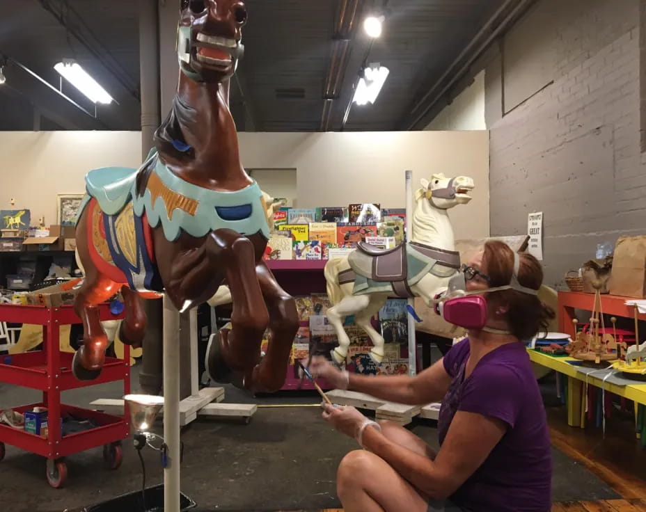 a woman working on a horse statue