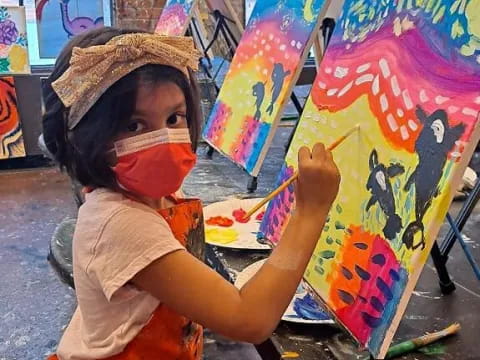 a young boy painting on a wall