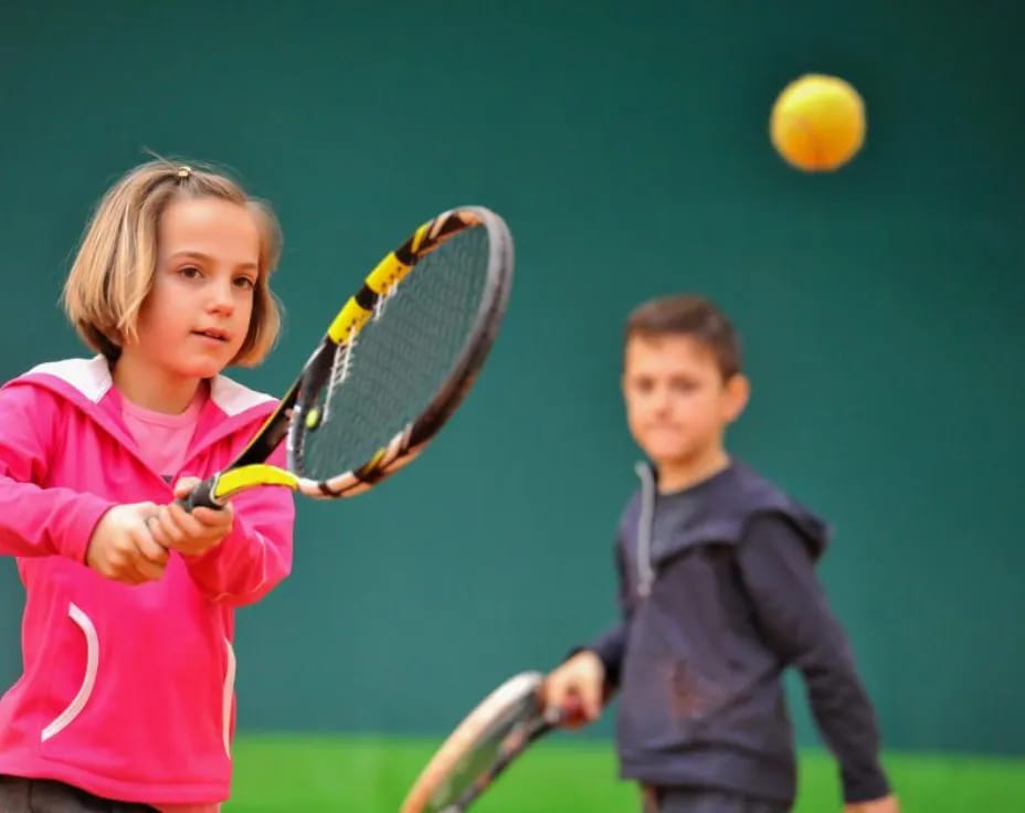 a couple of kids playing tennis