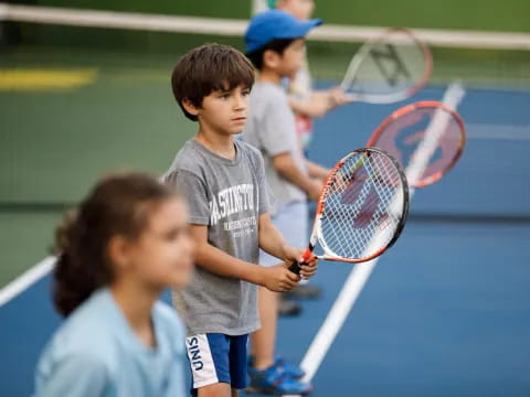 kids holding tennis rackets