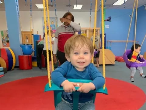 a boy sitting on a swing