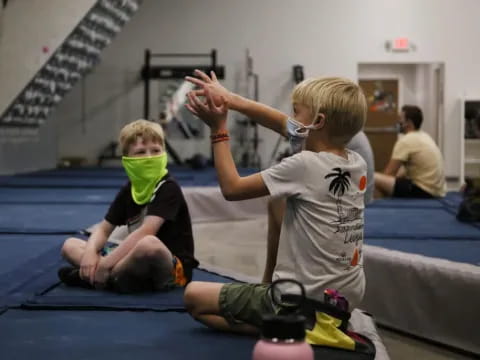 a few boys sitting on the floor