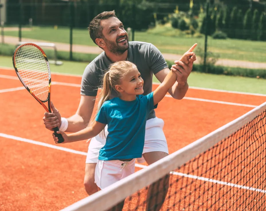 a person and a girl playing tennis
