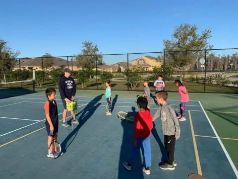 a group of kids playing tennis