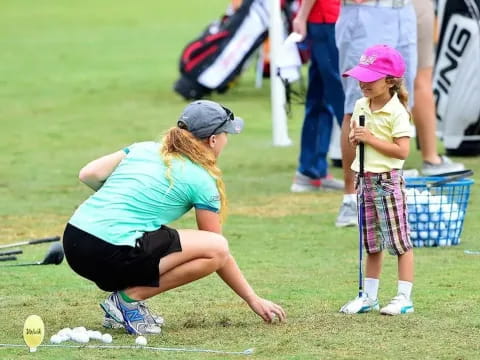 a person and a girl playing golf