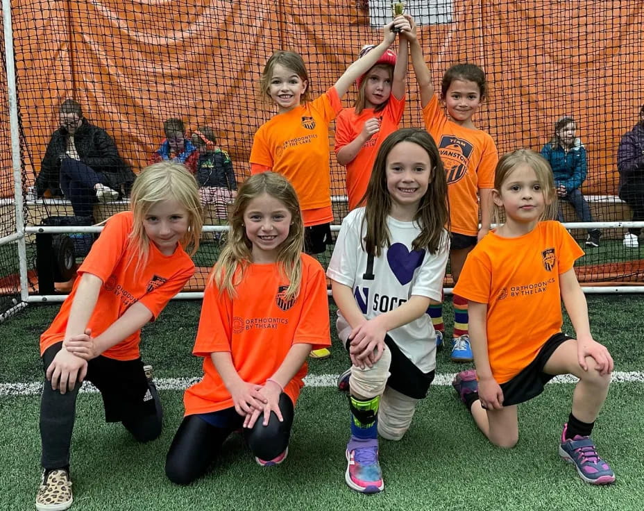 a group of girls in orange shirts