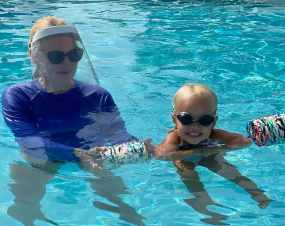 a person and a baby in a pool