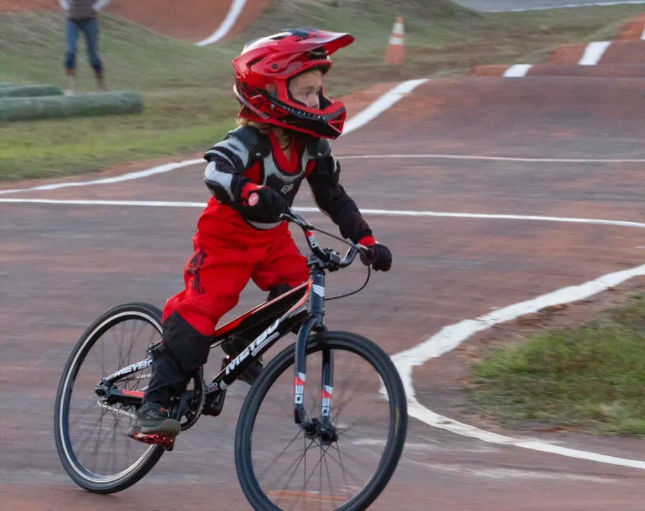 a boy riding a bicycle on a track