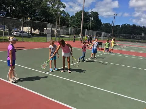 a group of kids playing tennis