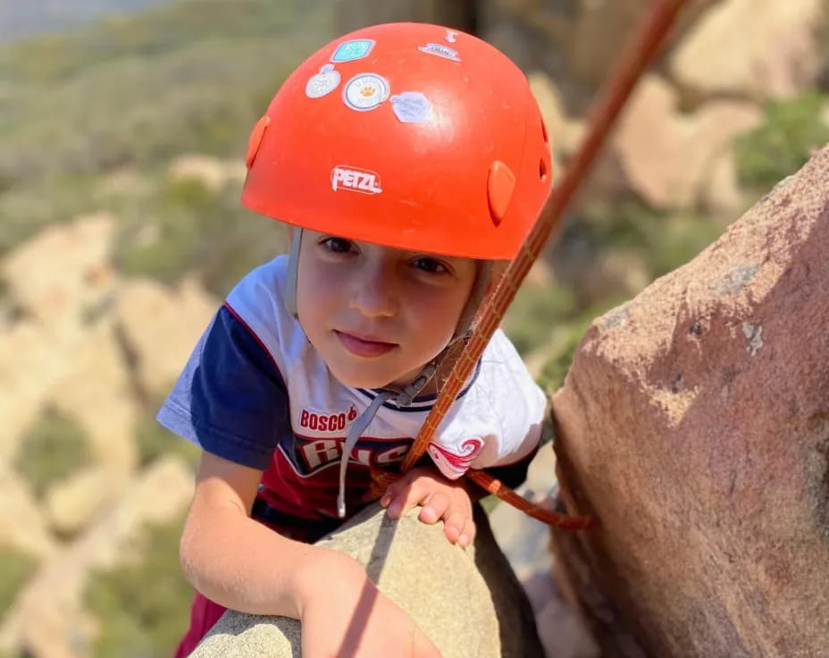 a young boy climbing a rock