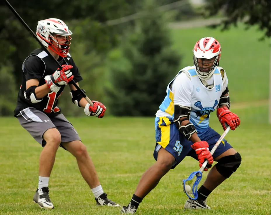 a couple of men playing lacrosse