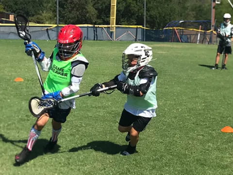 kids playing lacrosse on a field