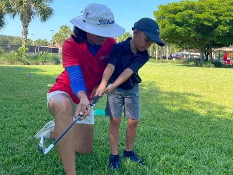 a person and a boy playing golf