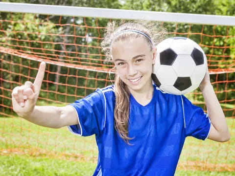 a girl holding a football ball