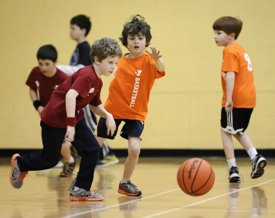 a group of kids playing basketball