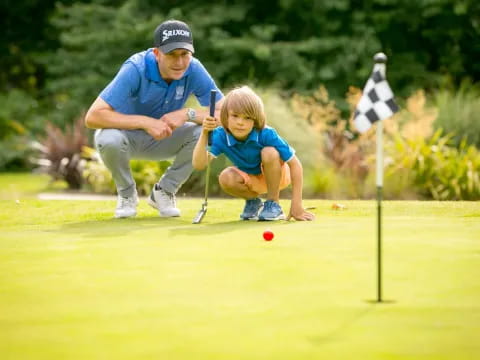 a person and a child playing golf