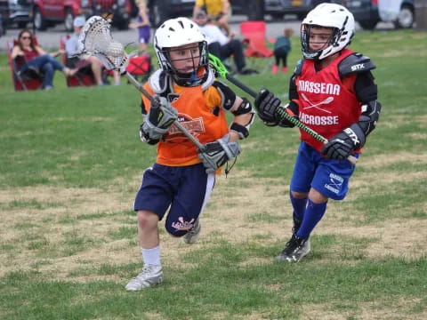 two kids playing lacrosse