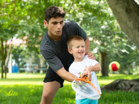 a person and a boy playing tennis
