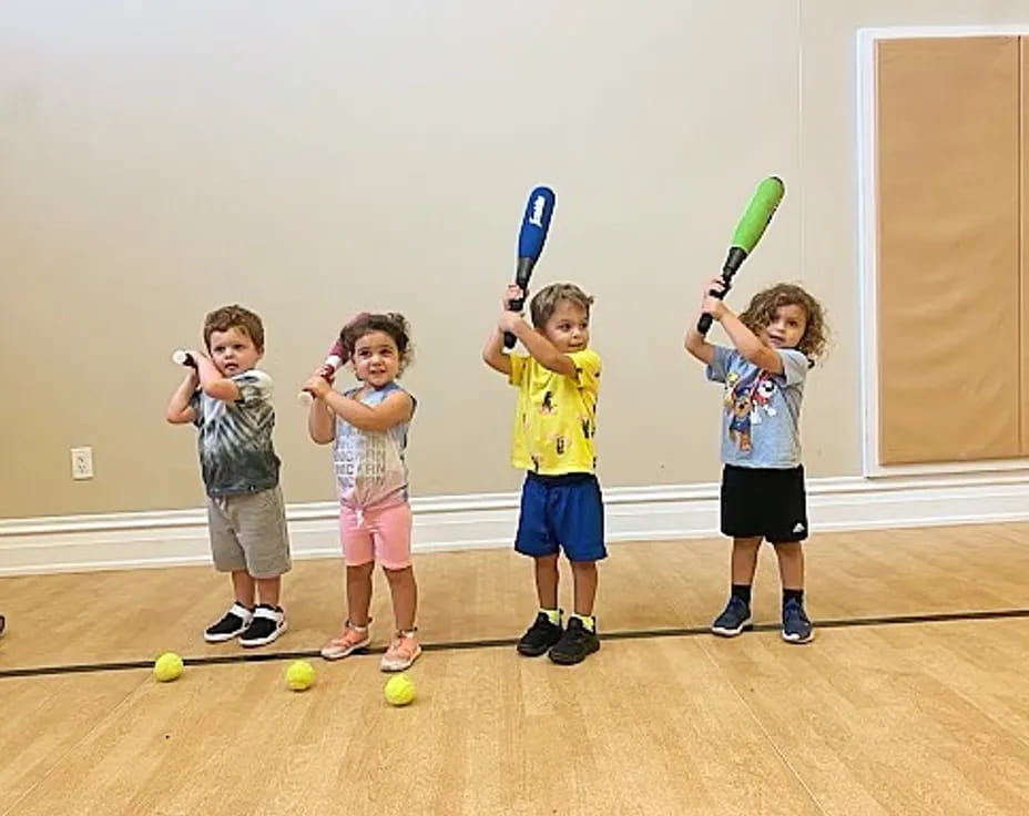 kids holding bats and balls