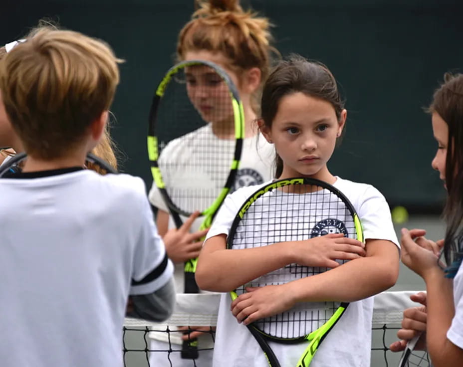 a group of kids playing tennis