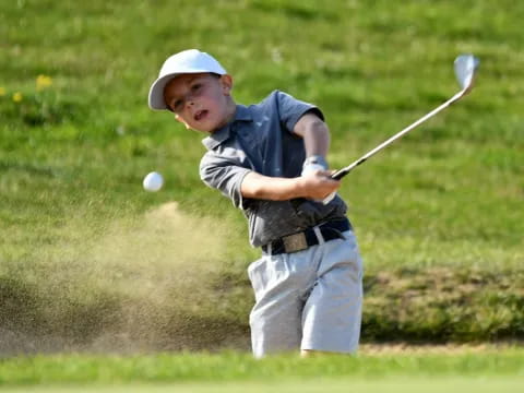 a boy swinging a golf club