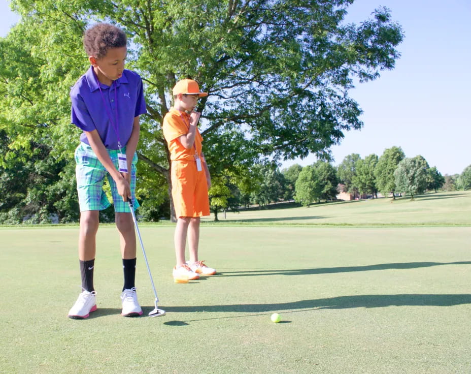 a person and a boy playing golf
